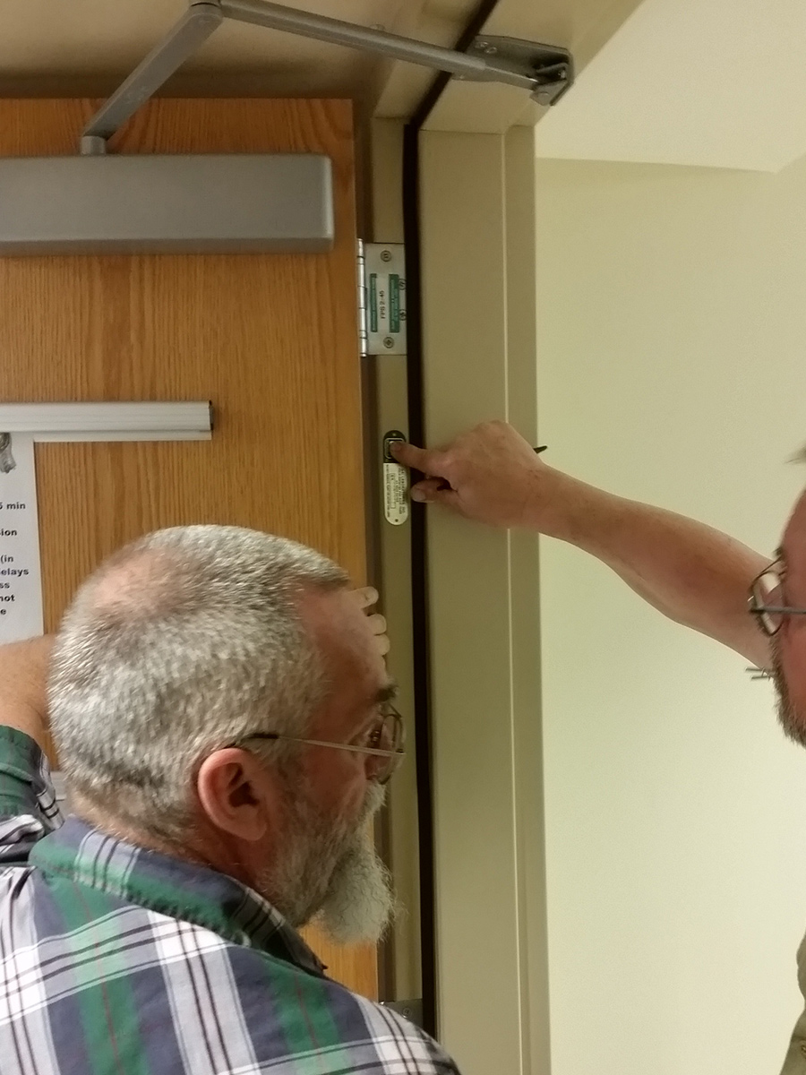 two men inspect door to make sure its up to code